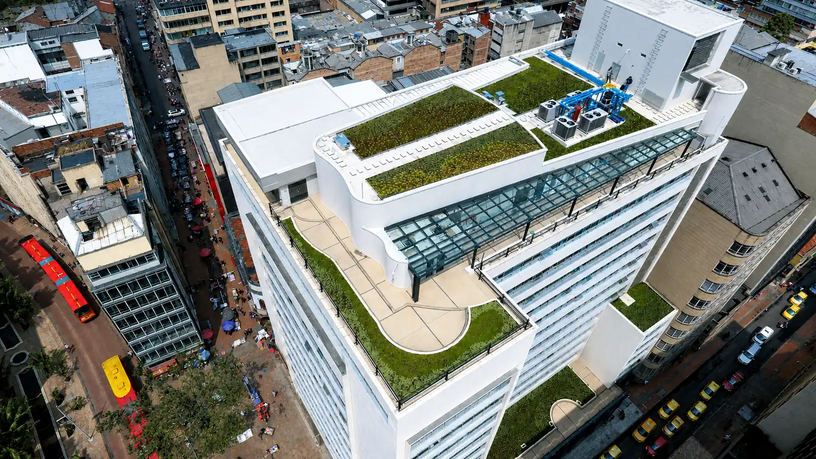Vista aérea de un edificio blanco con cubiertas verdes y terraza