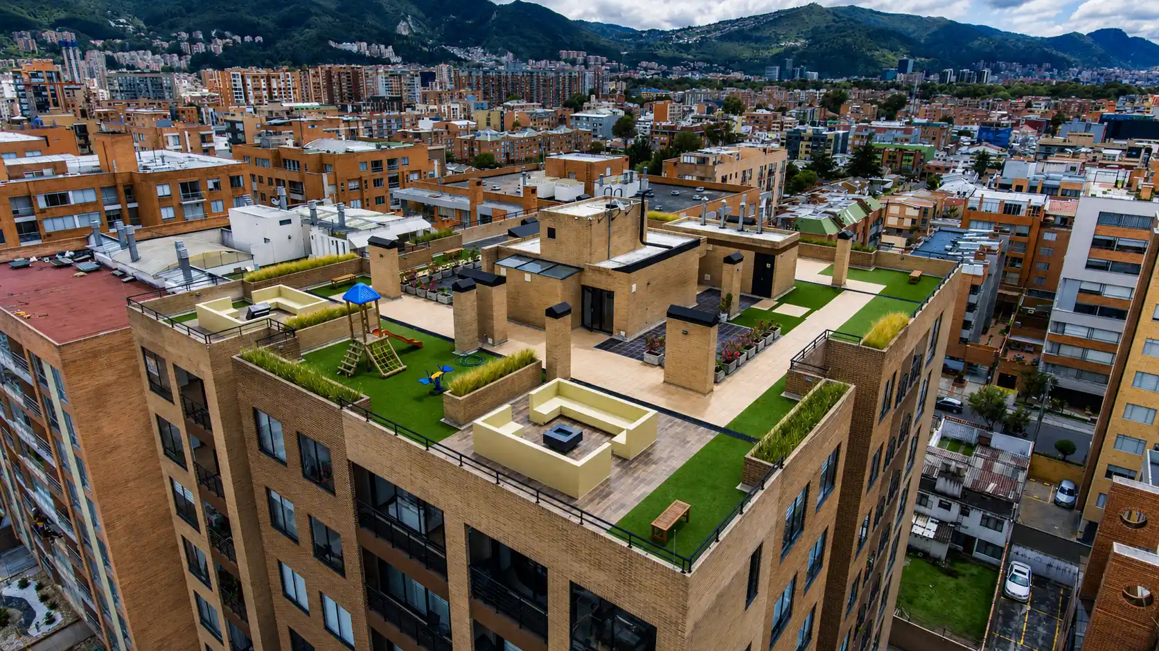 Terraza de edificio residencial con zonas verdes, juegos infantiles y salas exteriores