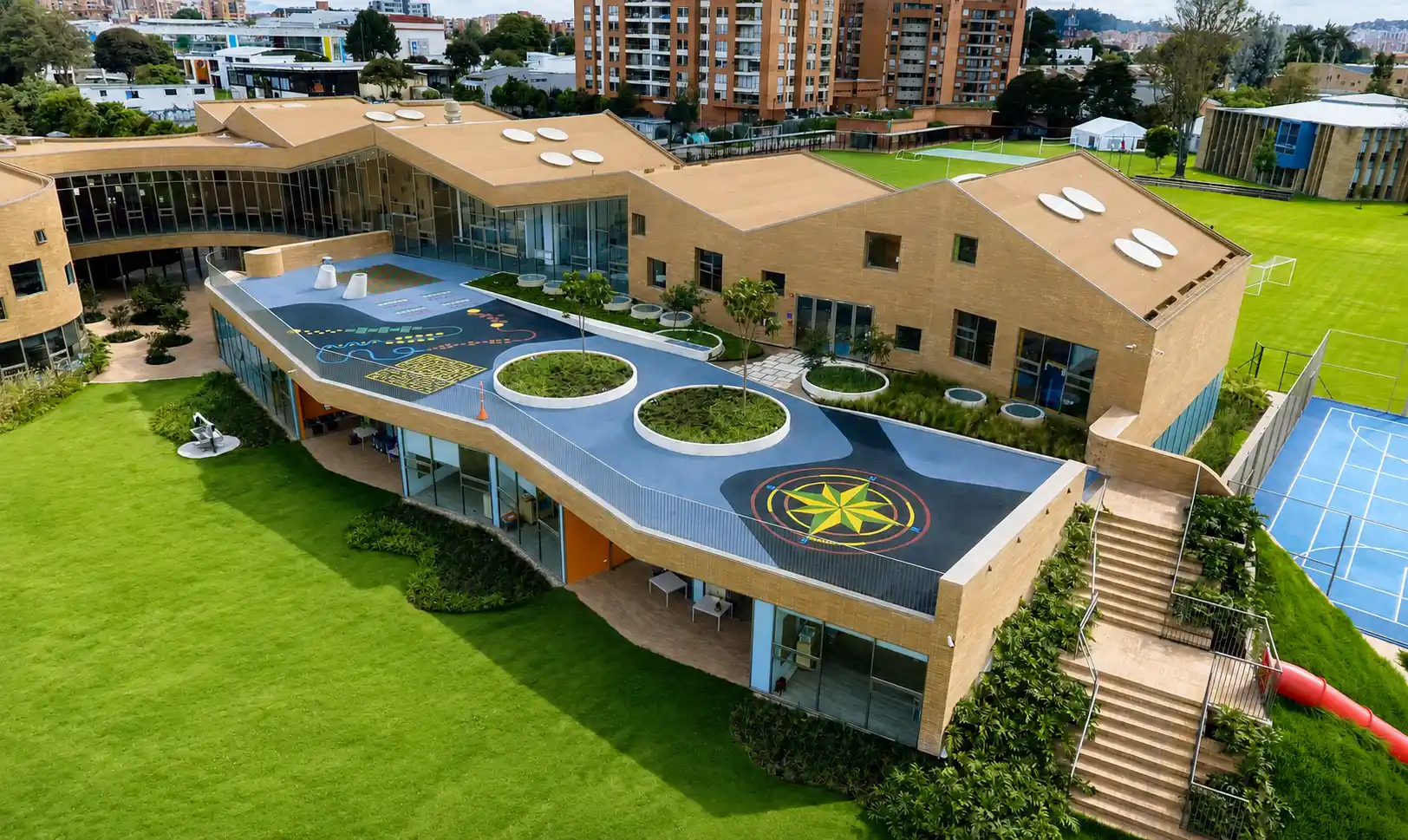 Colegio con terraza de juegos y jardineras circulares sobre la cubierta